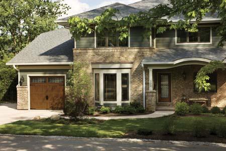 Clopay Gallery Collection polyurethane insulated garage door with a Medium Oak Ultra-Grain paint finish shown with a complementing Clopay stained fiberglass entry door. Both models feature Trenton decorative glass